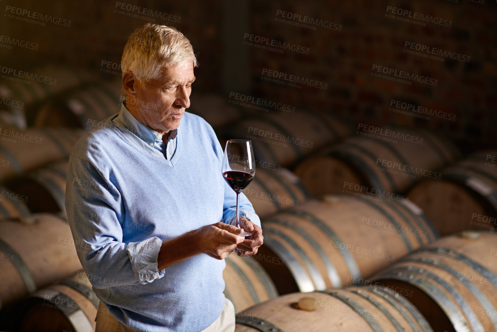 Buy stock photo Cropped shot of a senior man wine tasting in a cellar