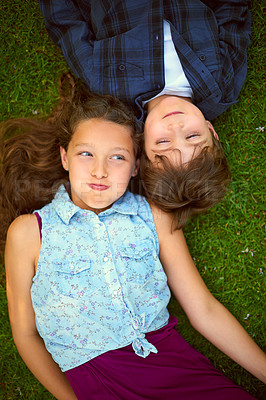 Buy stock photo High angle shot of a young brother and sister holding their breath while lying on the grass outside