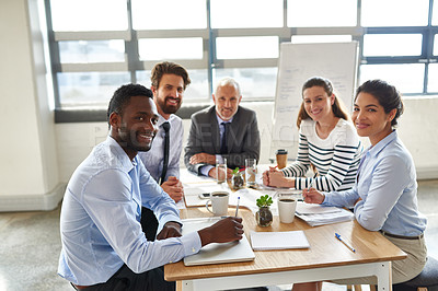 Buy stock photo Shot of a group of coworkers sitting around a table in the boardroom