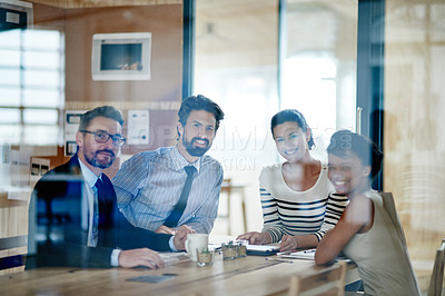 Buy stock photo Through the glass portrait of a group of colleagues working together in an office