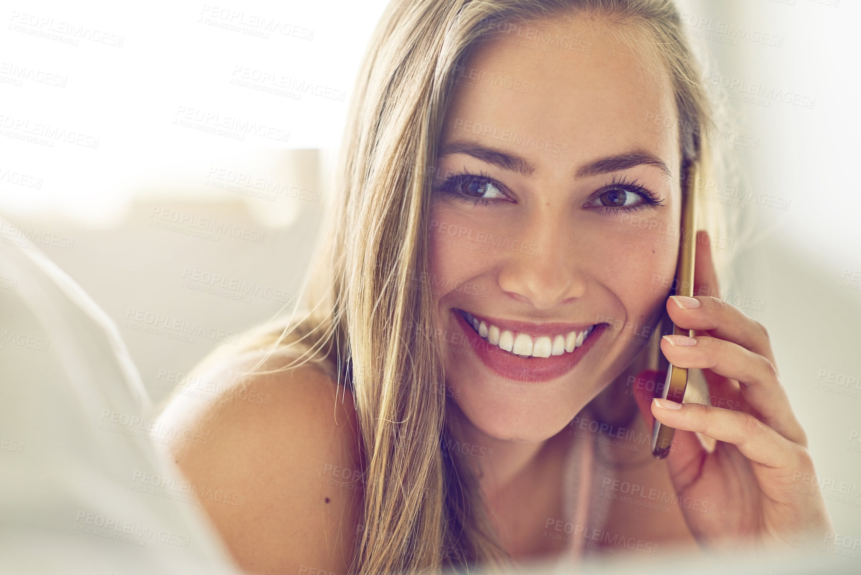 Buy stock photo Shot of a young woman talking on her phone at home