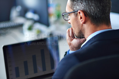 Buy stock photo Shot of a businessman using a laptop in the office