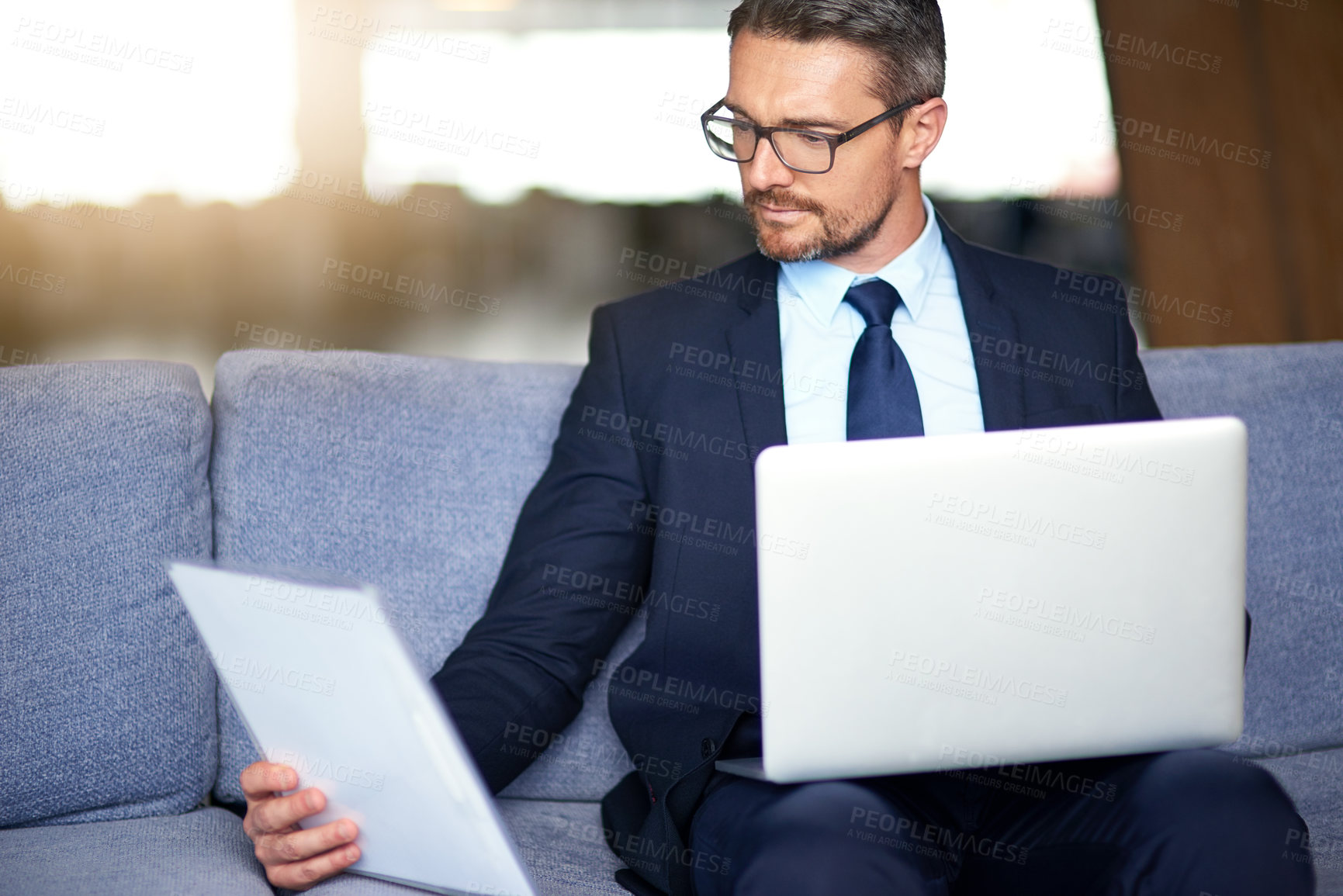 Buy stock photo Businessman, laptop and research paperwork as accountant for economy, review or investment. Male person, finance and reading document for bookkeeping banking with company revenue, report or budget