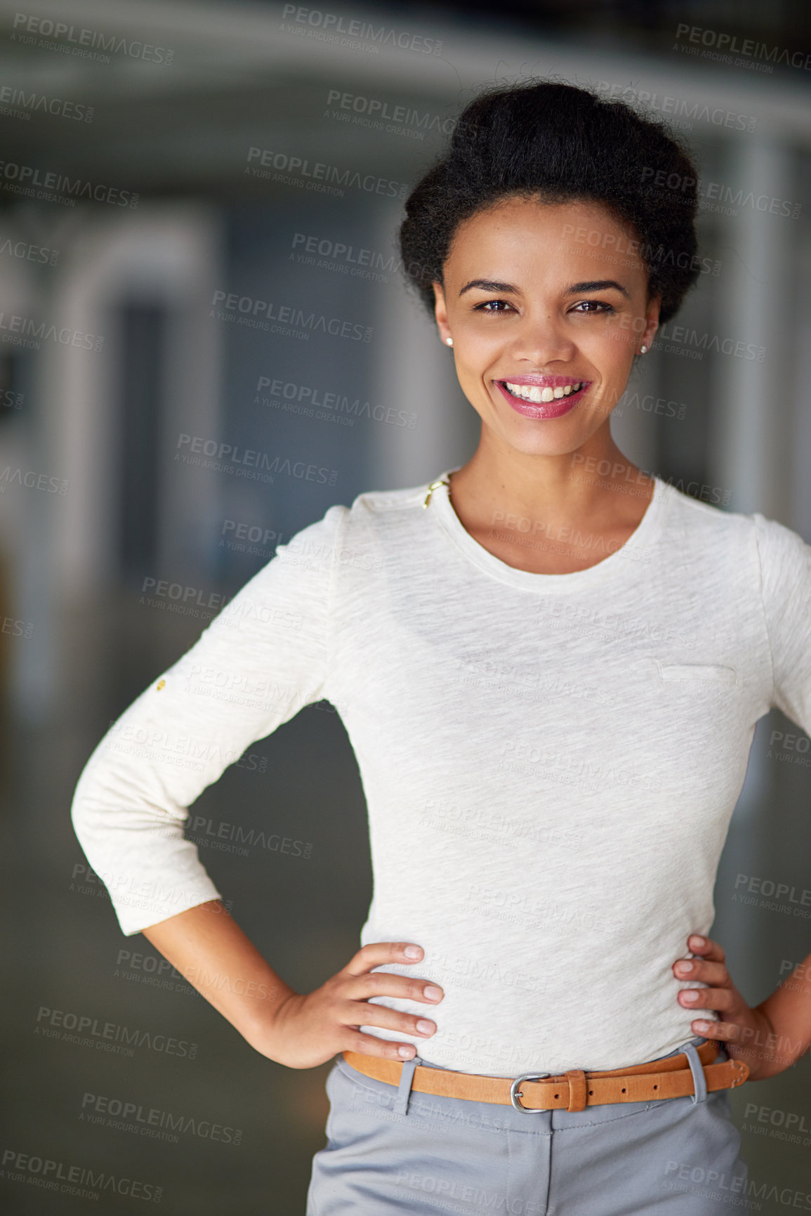Buy stock photo Cropped portrait of a young businesswoman standing with her hands on her hips in the office