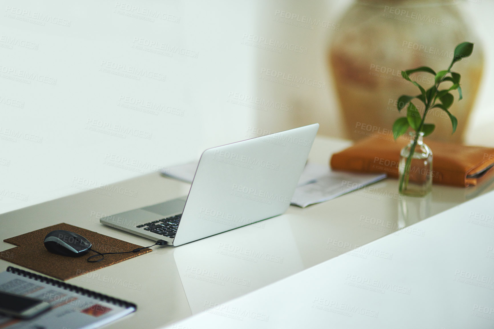 Buy stock photo Shot of a laptop on a desk in a creative business space