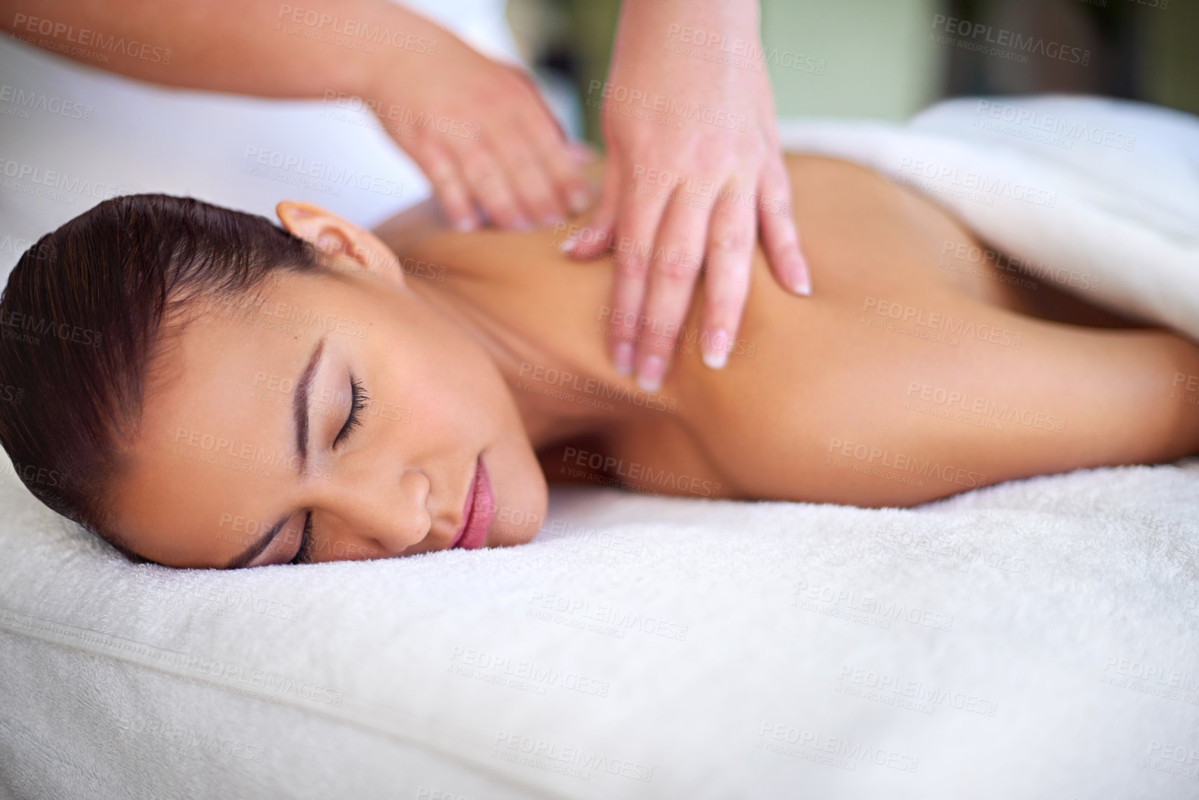 Buy stock photo Shot of a young woman enjoying a back massage at a spa