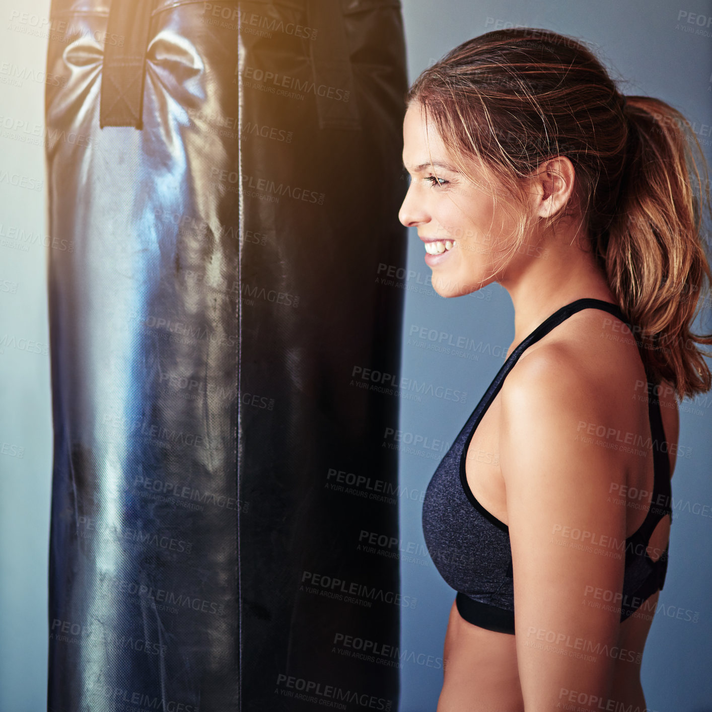 Buy stock photo Woman, punching bag and smile in gym for training, mma and excited for competition, sports and fitness. Person, happy and ready for martial arts, workout and exercise for combat, fight or contest