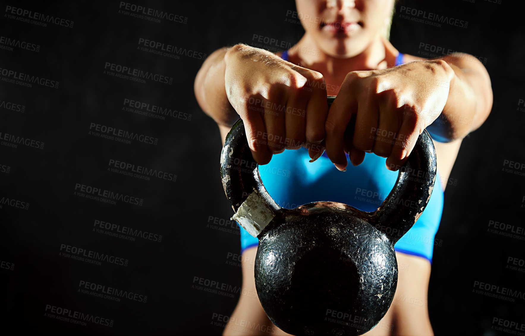 Buy stock photo Cropped shot of a young woman working out using a kettlebell