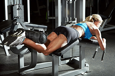 Buy stock photo Shot of a young woman using an exercise machine at the gym