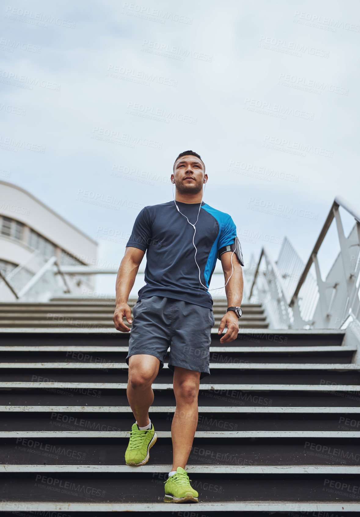 Buy stock photo Man, fitness and exercise on stairs outdoor for running, workout and competition training with earphones. Athlete, wellness and cardio in morning for health, jog and sports performance with music