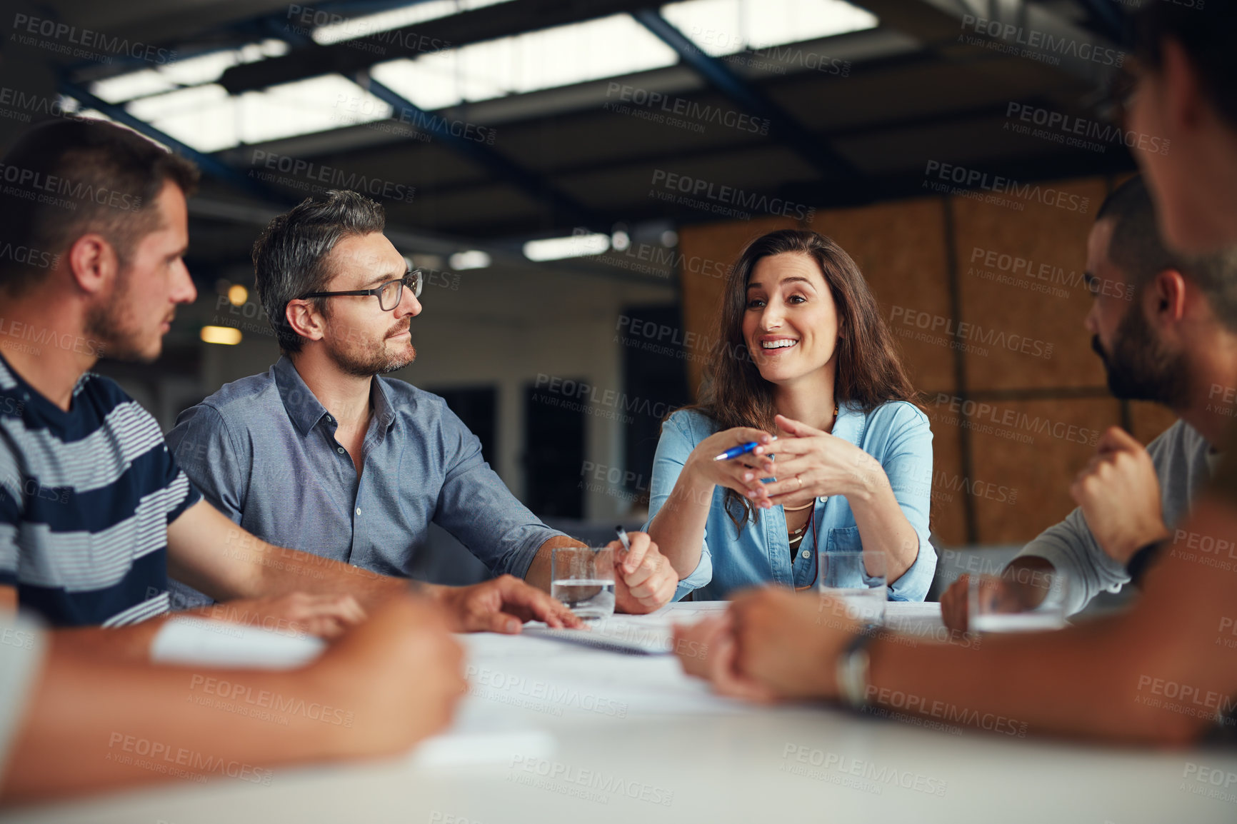 Buy stock photo Shot of a group of coworkers having a meeting in an open plan office