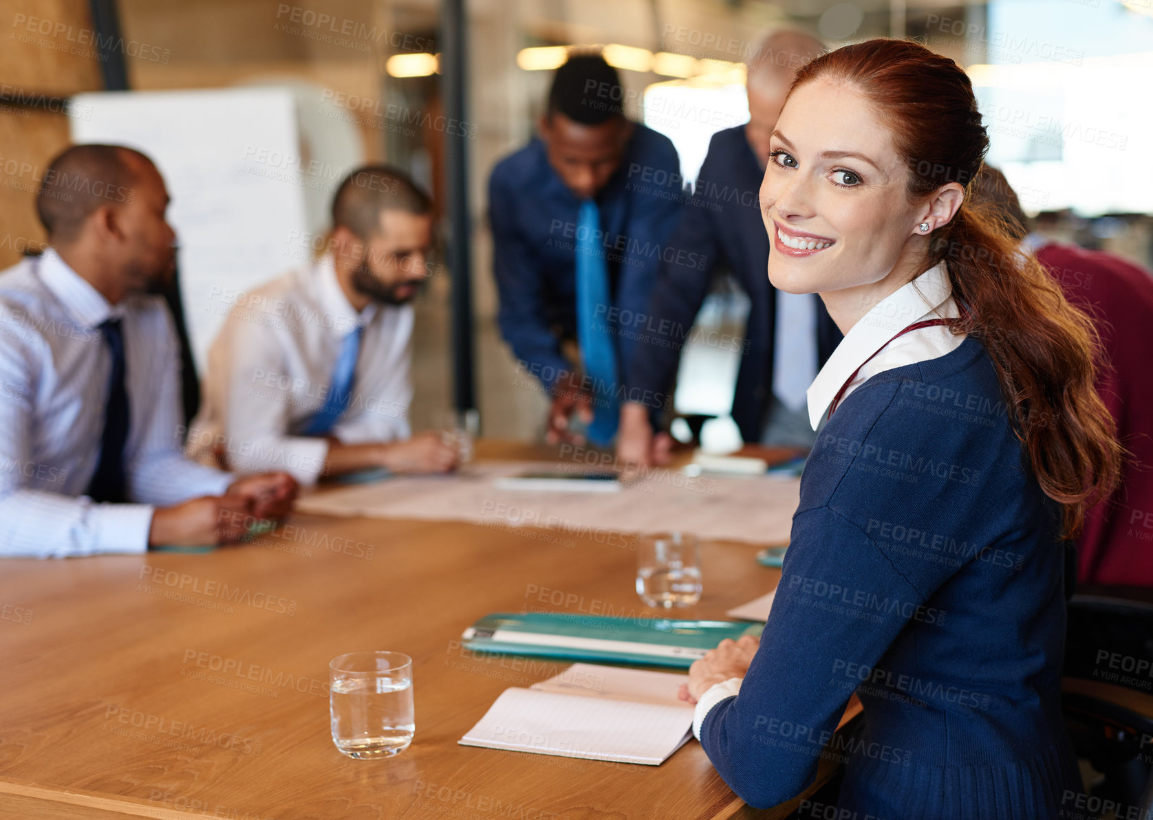 Buy stock photo Portrait of a young businesswoman with her colleagues in the background