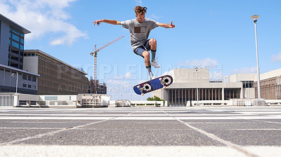 Buy stock photo Shot of a young man skateboarding through the city