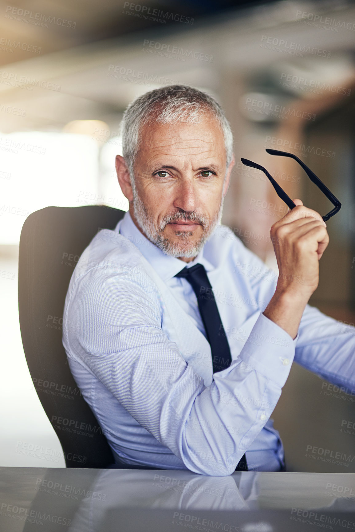 Buy stock photo Cropped portrait of a mature businessman working in his office