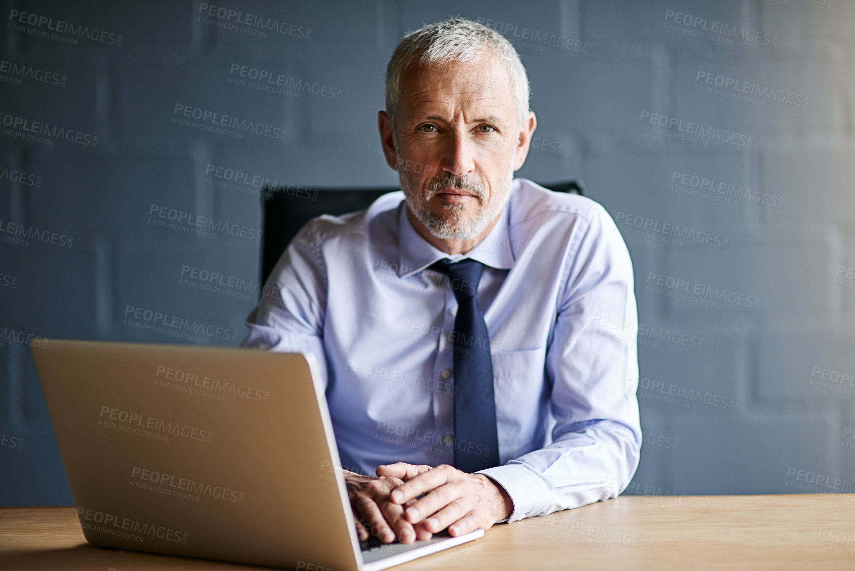 Buy stock photo Cropped portrait of a mature businessman working in his office