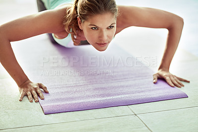 Buy stock photo Shot of a young woman doing push-ups during a workout