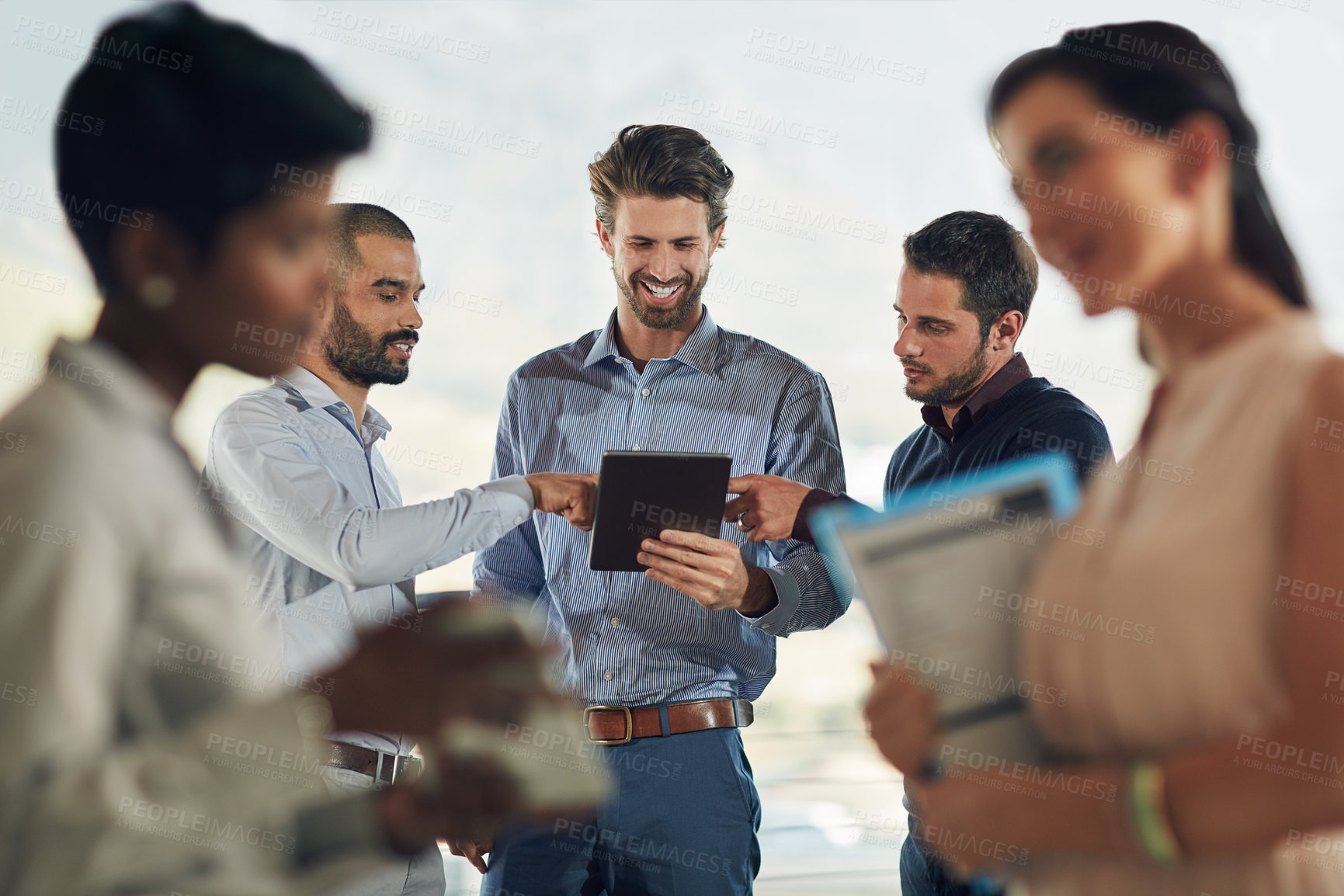 Buy stock photo Cropped shot of a group of businesspeople standing around in the office