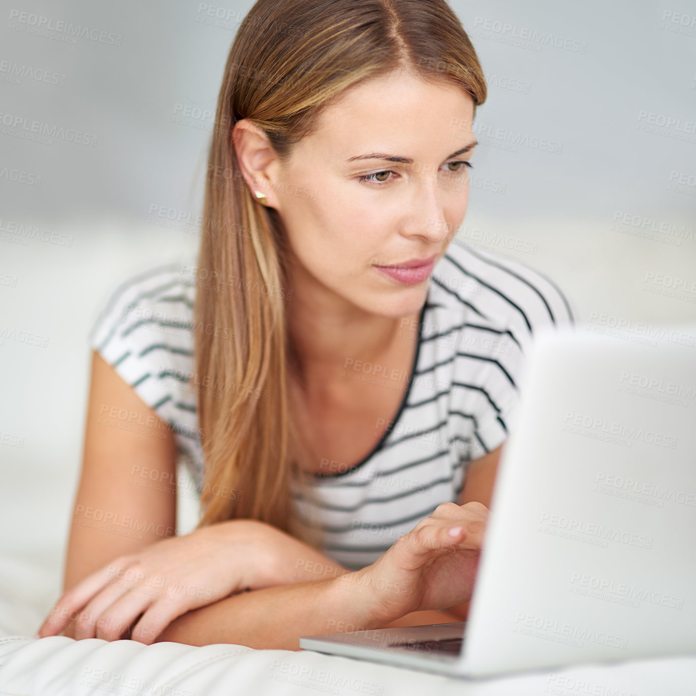 Buy stock photo Shot of a young woman browsing the internet at home 