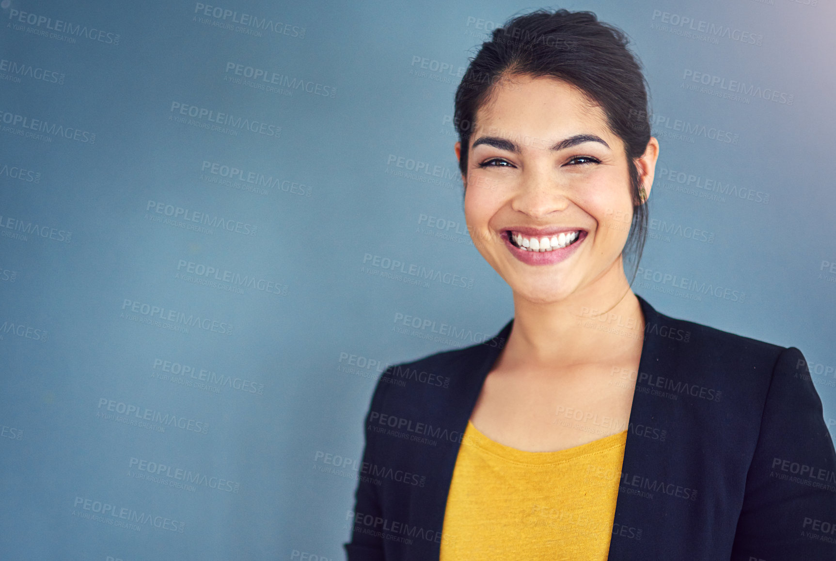 Buy stock photo Studio portrait of an attractive young businesswoman standing against a blue background