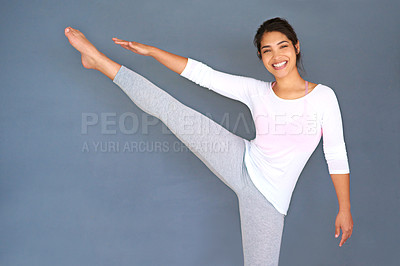 Buy stock photo Cropped shot of a sporty young woman doing yoga against a grey background