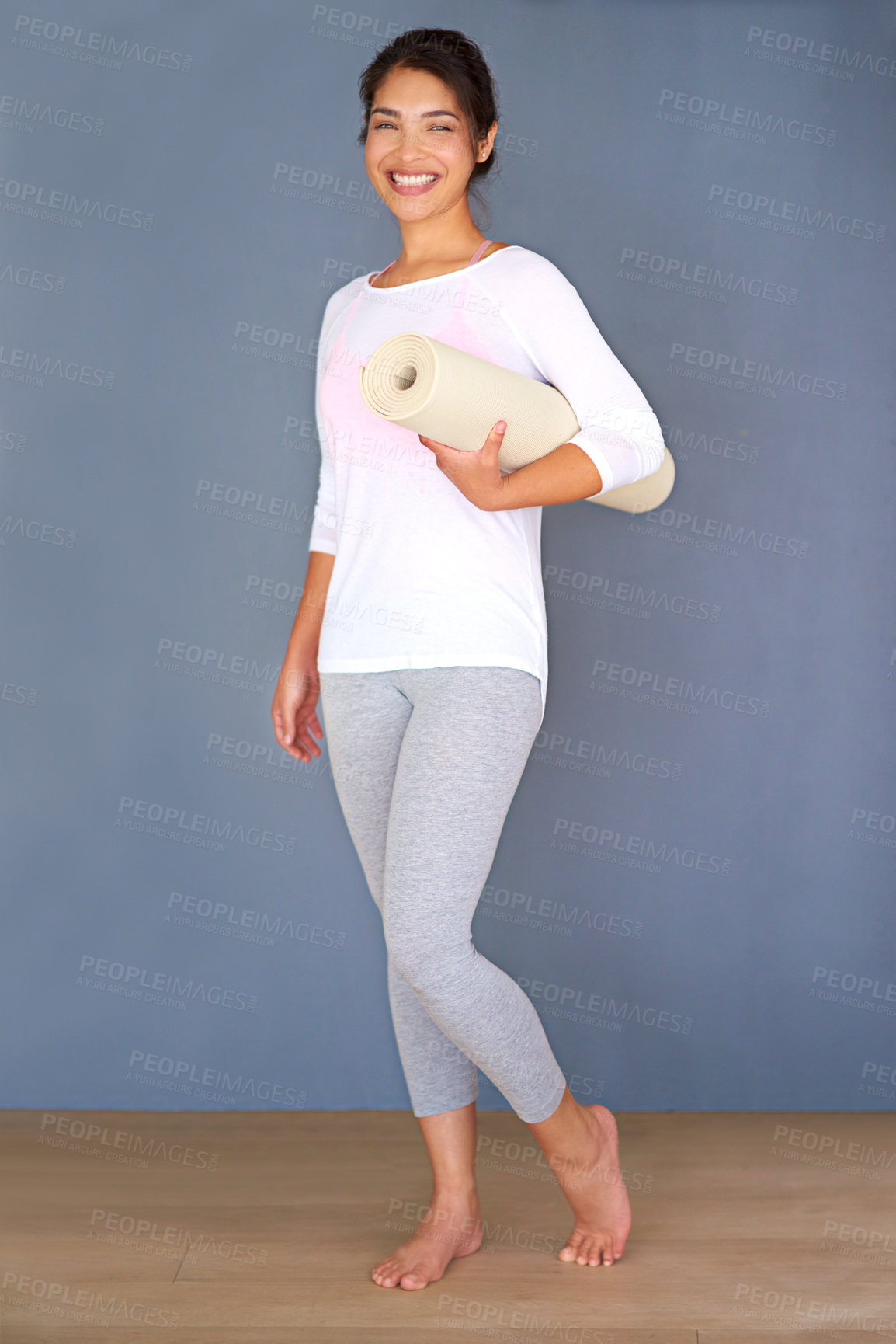 Buy stock photo Portrait, yoga mat and happy woman by wall for fitness, exercise and healthy body on grey background. Pilates, smile and girl with equipment for wellness or holistic practice on mockup space in gym