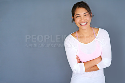 Buy stock photo Cropped shot of a sporty young woman standing with her arms folded against a grey background