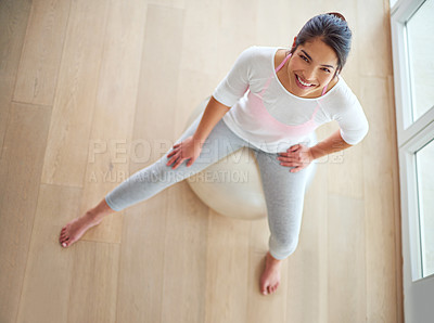 Buy stock photo High angle shot of a young woman sitting on a swiss ball