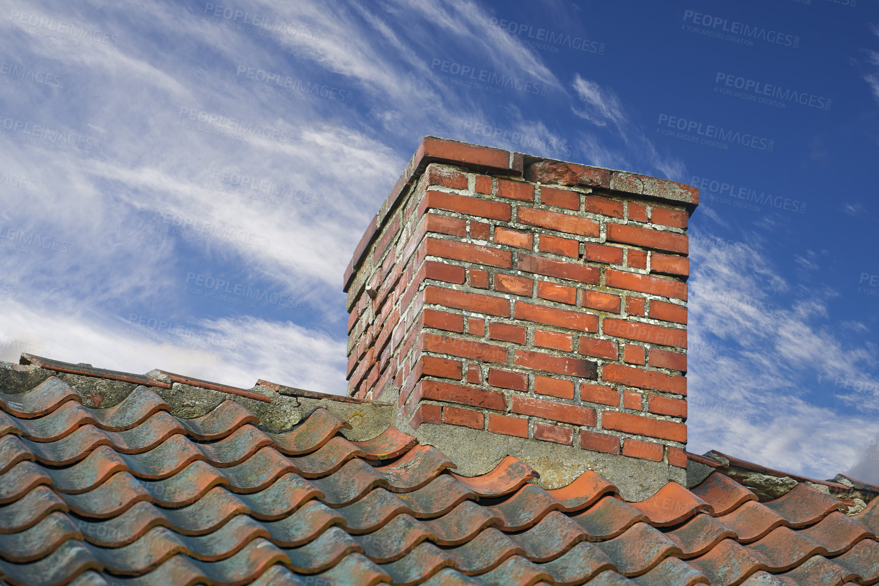 Buy stock photo Red brick chimney designed on slate roof of house building outside against blue sky with white clouds background. Construction of exterior escape chute built on rooftop for fireplace smoke and heat