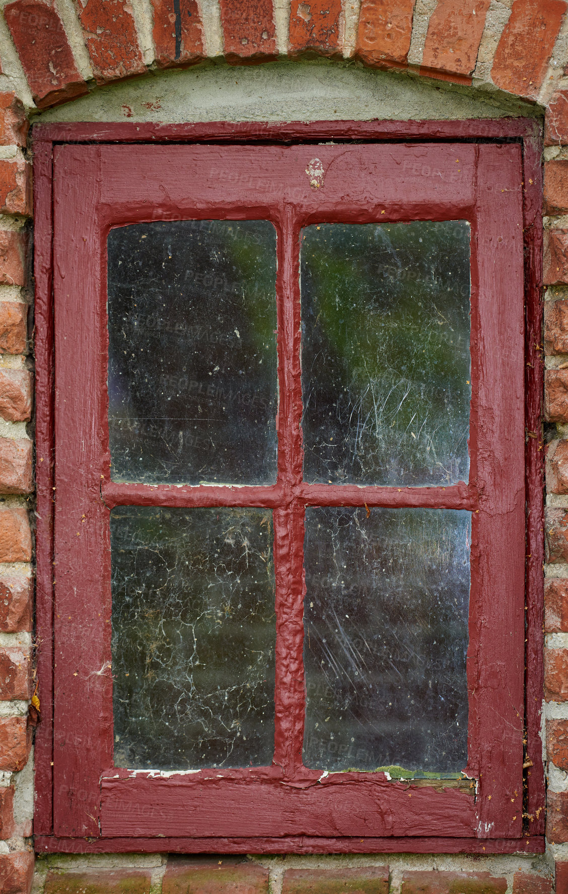 Buy stock photo Old dirty window of a brick wall house or home. Ancient casement with red metal frame on a historic building with a clumpy paint texture. Exterior details of a windowsill in a traditional country town