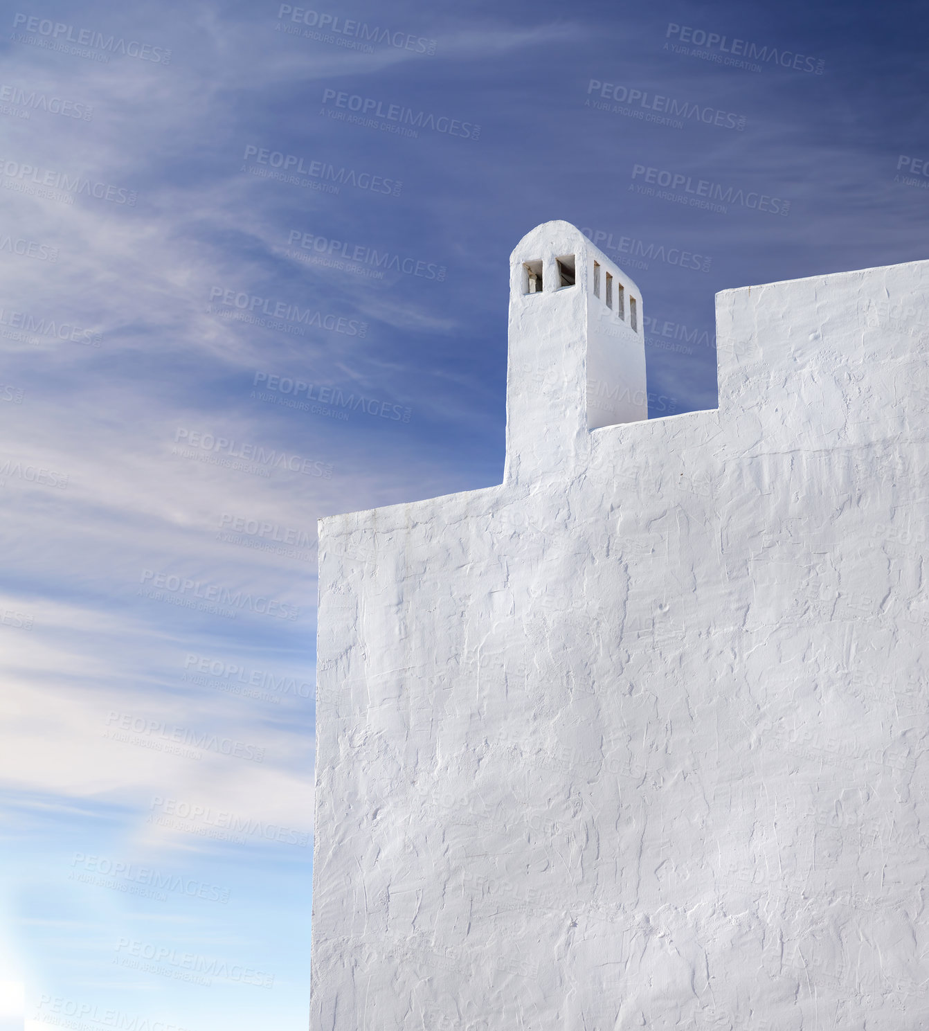 Buy stock photo Chimney or bell tower designed on the roof of a white building outside against a cloudy blue sky background with copyspace. Construction of exterior with architectural arch at a historical monument