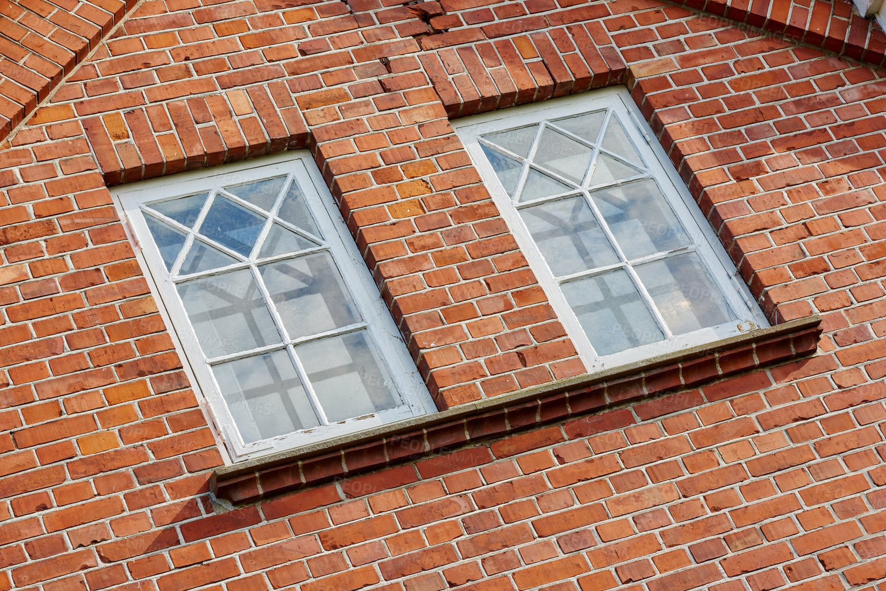 Buy stock photo Old stone wall with two rectangular windows. Close up of rectangular windows of a building with a red brick wall. Patterned windows on a red stained brick wall of an old building or house