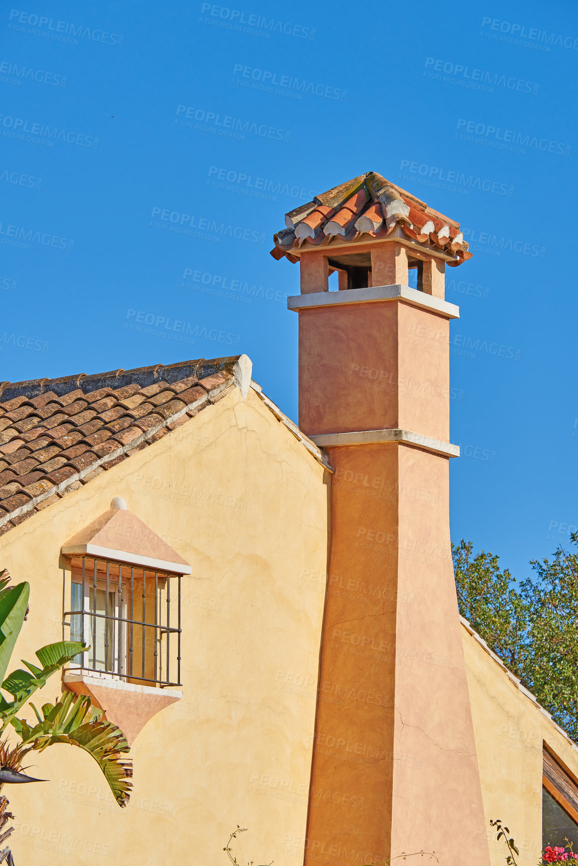 Buy stock photo Chimney designed on roof of orange painted house building outside against blue sky background. Construction of exterior architecture of escape chute built on rooftop for fireplace smoke and heat