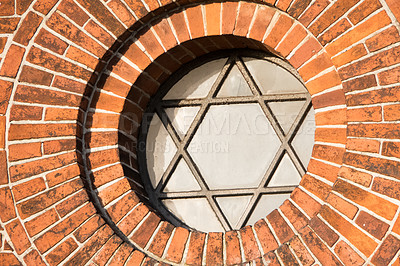 Buy stock photo View of a pentagram sign and symbol on an old round window on a red brick wall. Vintage glass with metal frame and pentagon on historic church building and background. Architecture circular design