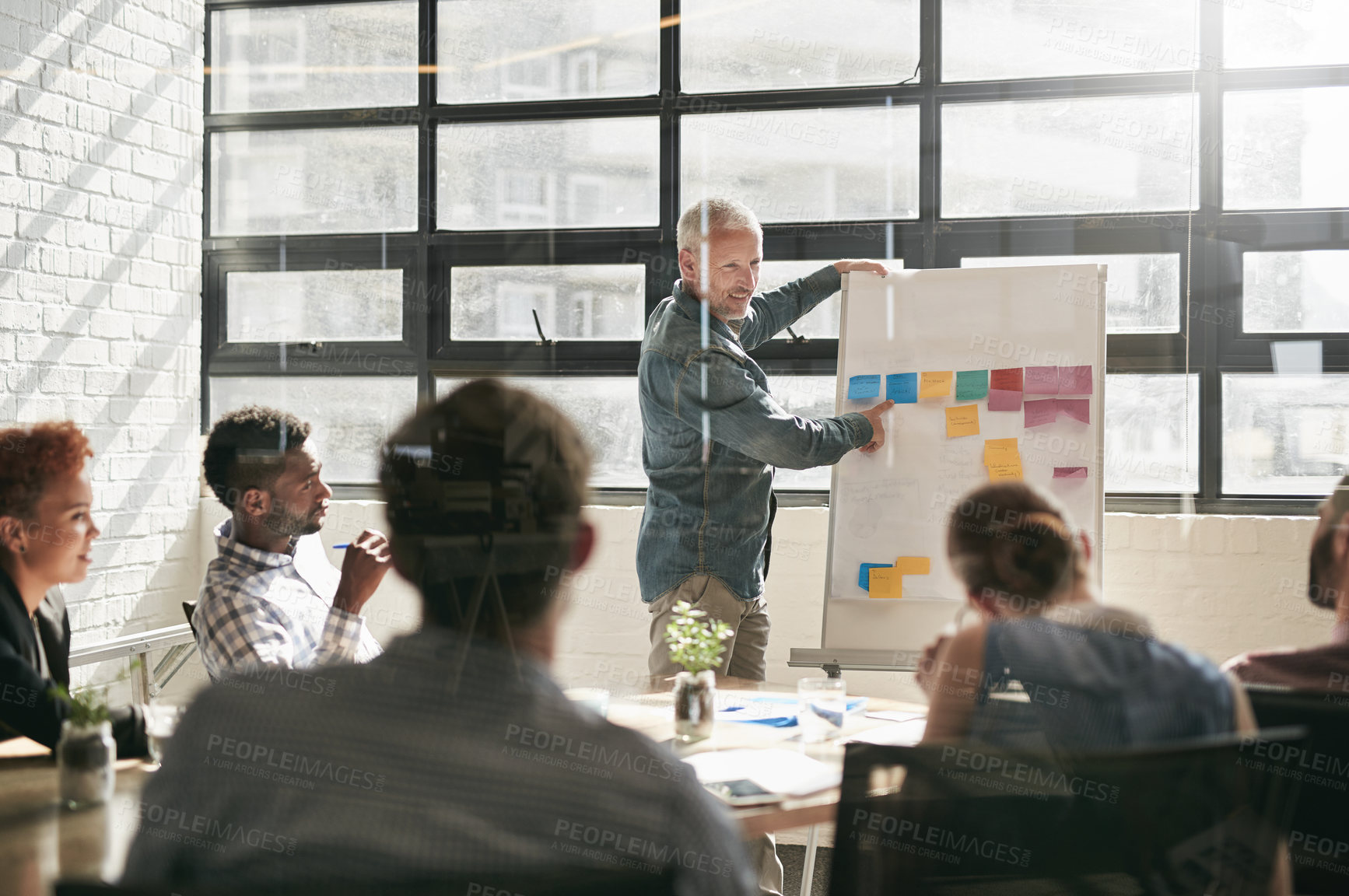 Buy stock photo Shot of a businessman giving a presentation to his colleagues