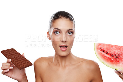 Buy stock photo Studio shot of a young woman unable to decide between a slab of chocolate or a piece of watermelon