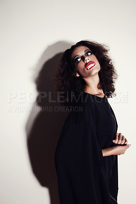 Buy stock photo Studio shot of a beautiful young fashion model with vampire teeth in her mouth