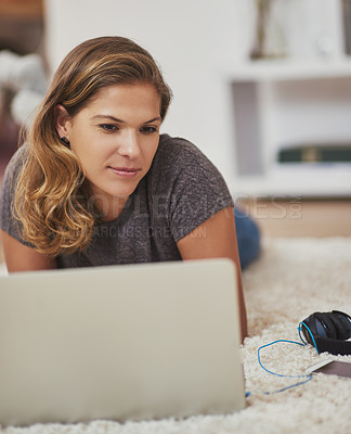 Buy stock photo Shot of a young woman relaxing at home with her laptop