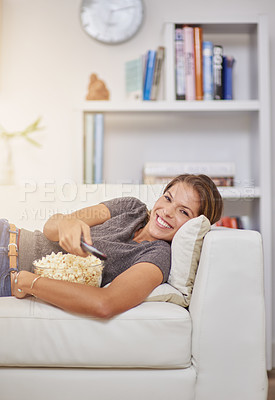 Buy stock photo Shot of a young woman spending a relaxing weekend at home watching tv