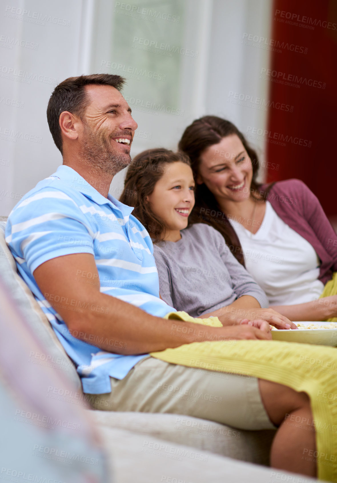 Buy stock photo Cropped shot of a family watching a movie on the sofa