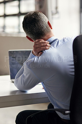 Buy stock photo Rearview shot of a mature businessman running his neck anxiously while working in his office