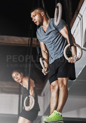 Buy stock photo Cropped shot of two young athletes working out on the gymnastics rings