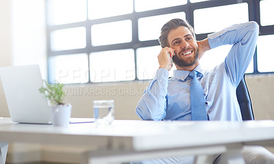 Buy stock photo Shot of a young businessman using his phone in the office