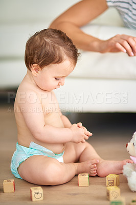 Buy stock photo Cropped shot of an adorable baby girl playing with wooden blocks at home