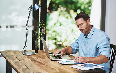 Buy stock photo Cropped shot of a businessman working on his laptop at home