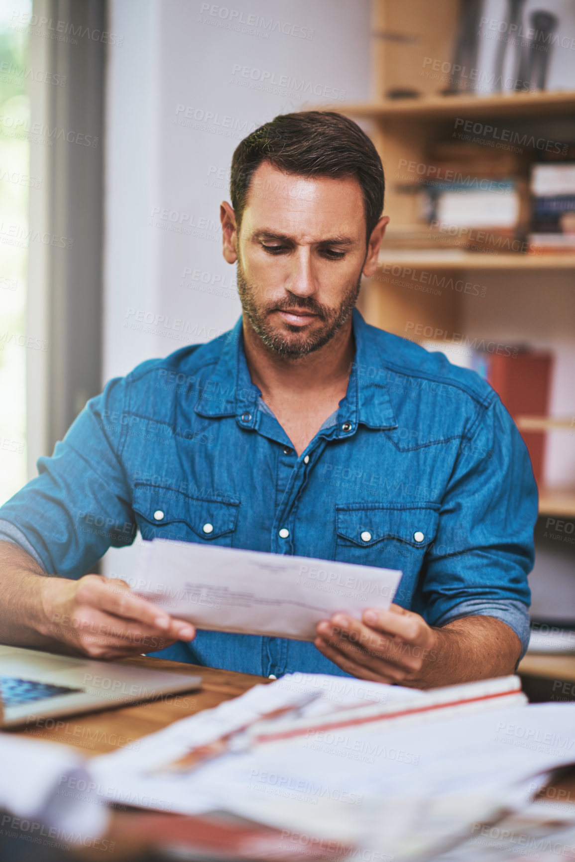 Buy stock photo Cropped shot of a businessman reading some paperwork at home