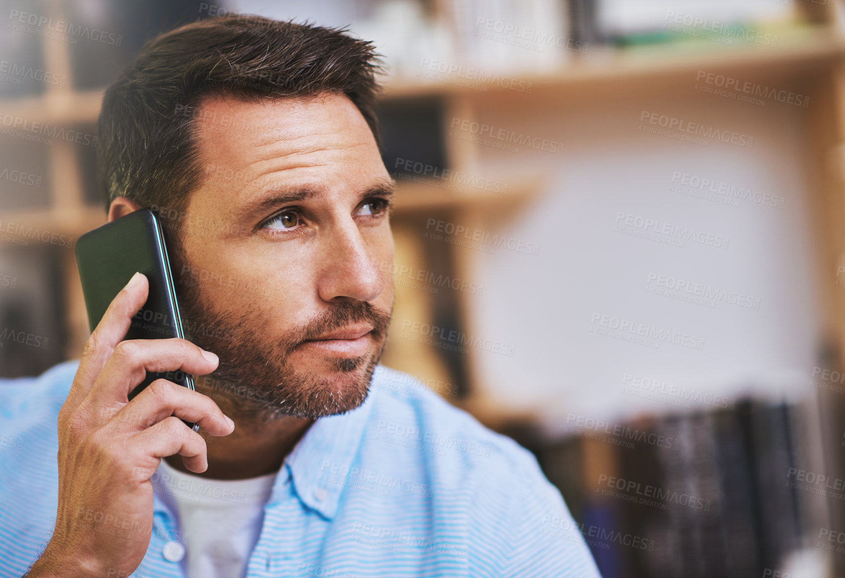 Buy stock photo Cropped shot of a businessman talking on his cellphone while working at home