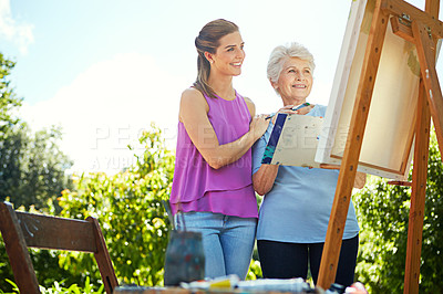 Buy stock photo Shot of a senior woman and her adult daughter painting in a park