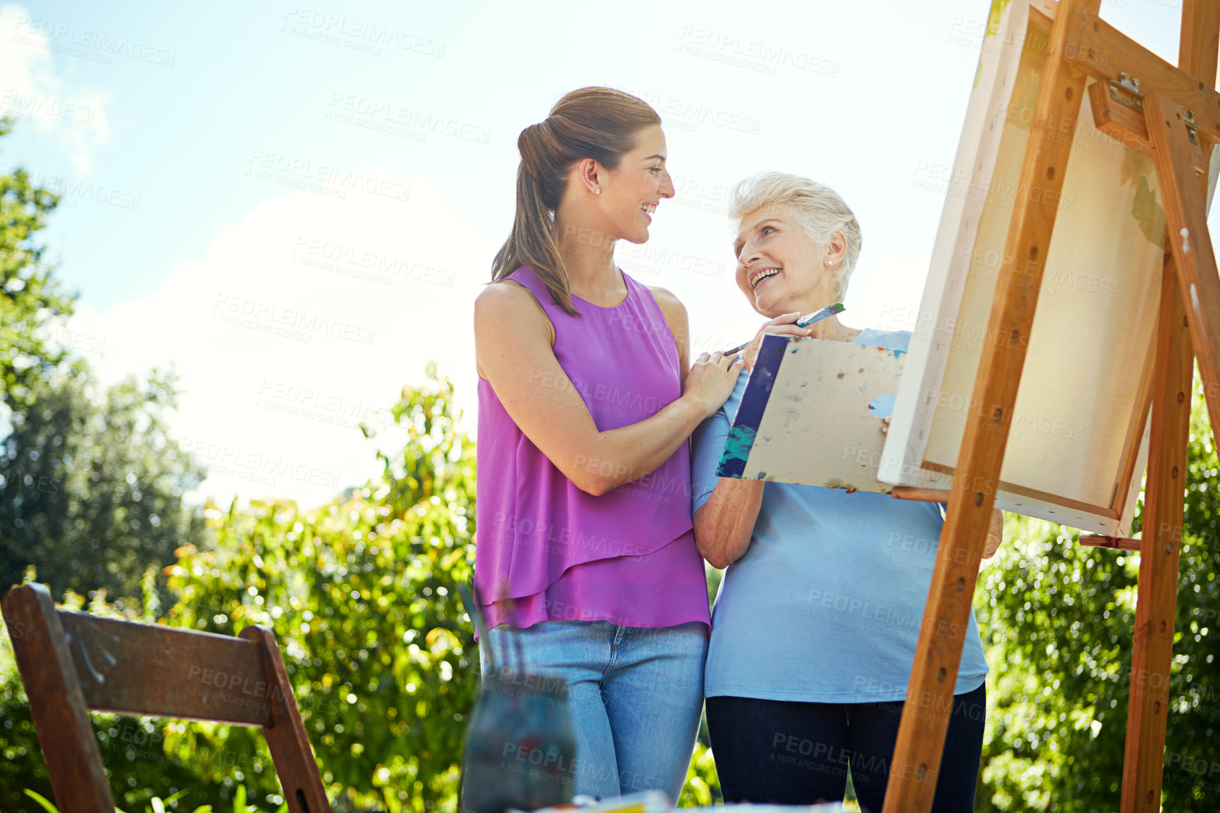 Buy stock photo Cropped shot of a young woman and her mother painting in the park