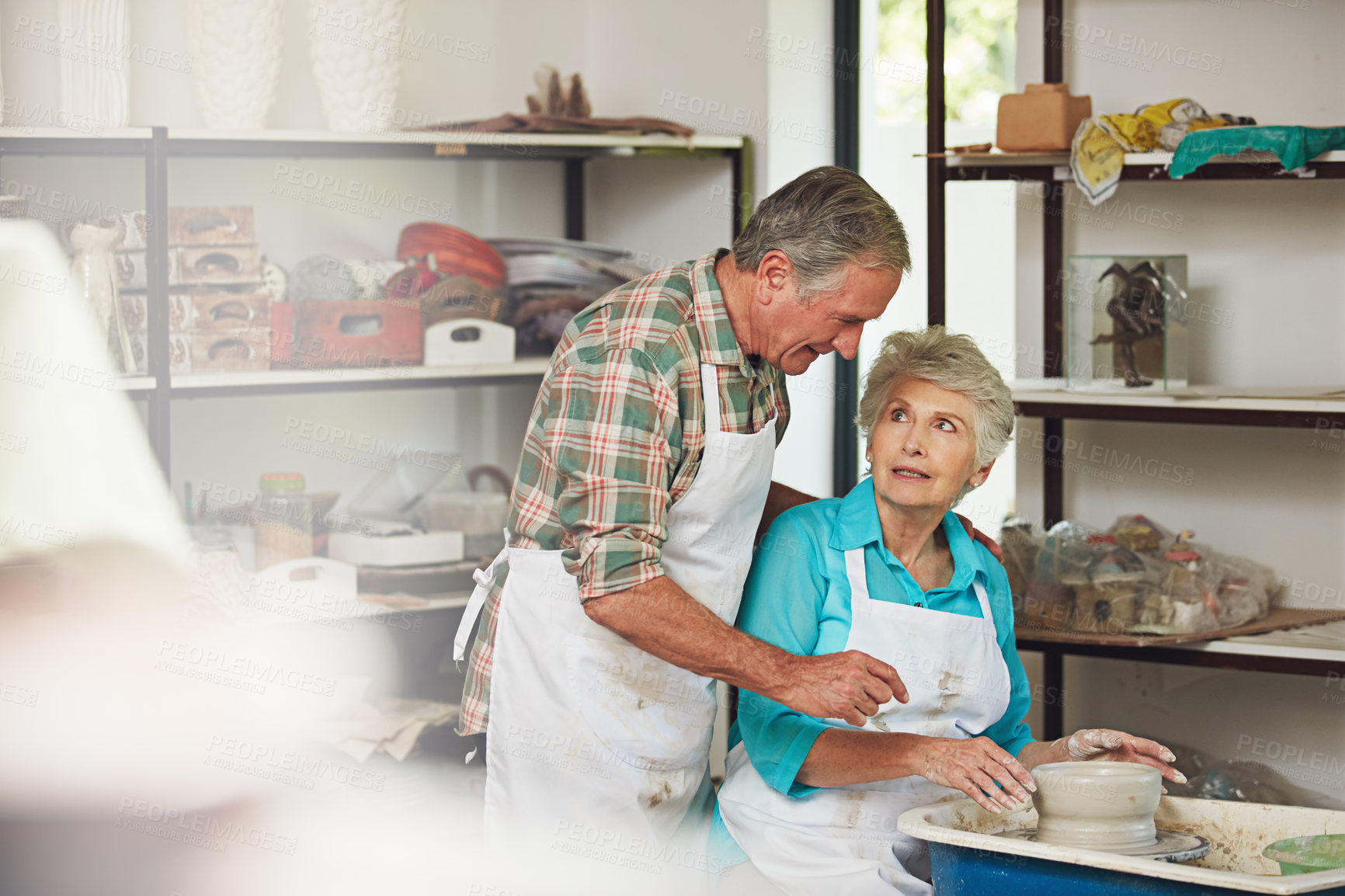 Buy stock photo Shot of a senior couple making a ceramic pot together in a workshop