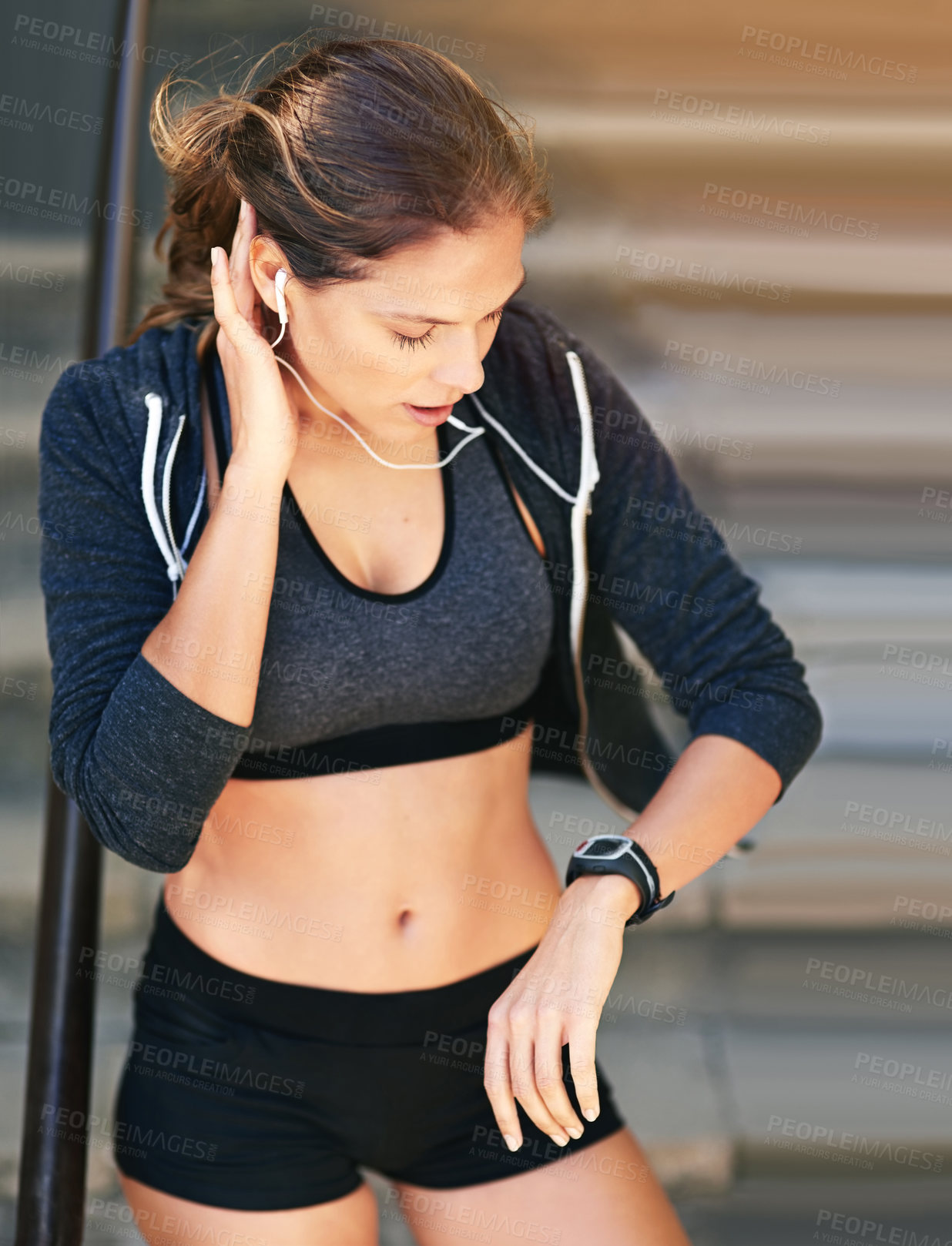 Buy stock photo Cropped shot of an attractive young athlete checking her watch after an outdoor workout